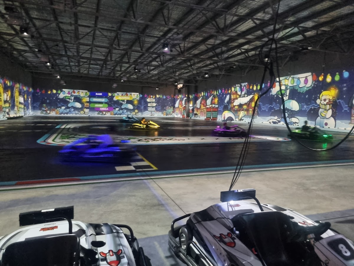 Kids and adults racing hire karts on an interactive indoor track